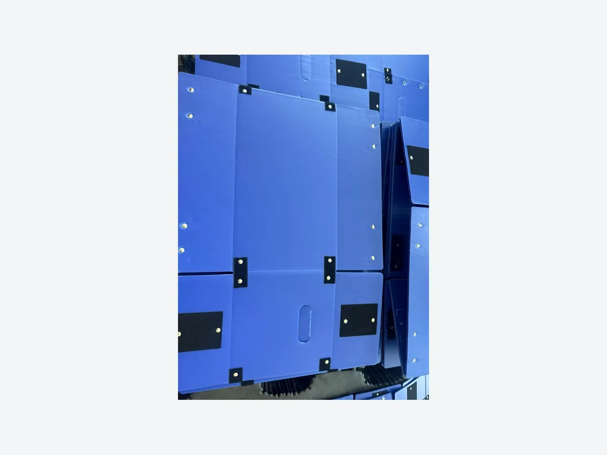 Close view of blue foldable PP corrugated box panels hinges and corner fittings