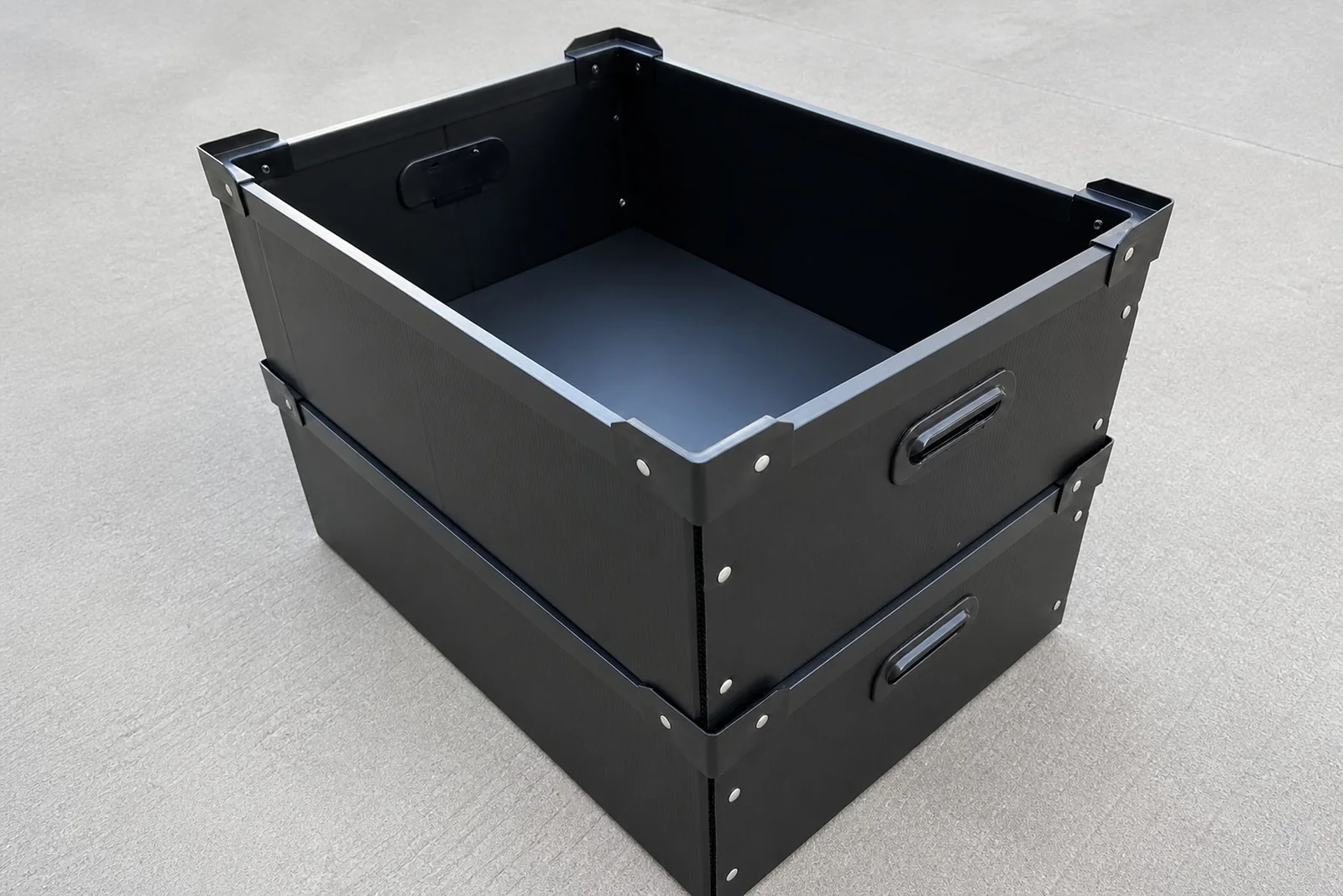 Two black PP corrugated returnable boxes with reinforced edges and handholds