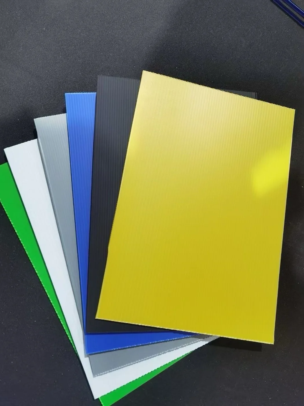 Colored corrugated plastic sheet samples showing available material formats