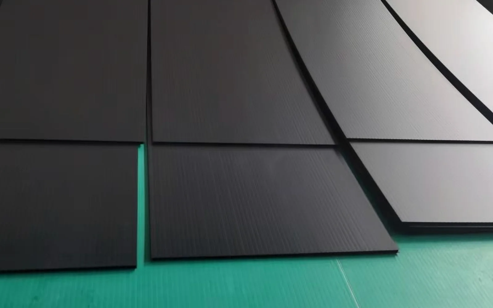 Black corrugated plastic sheet panels arranged at a processing station