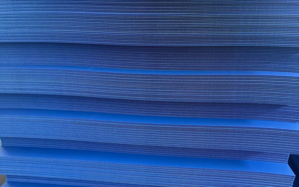 Blue PP corrugated plastic sheets stacked with twin-wall flute edges visible.